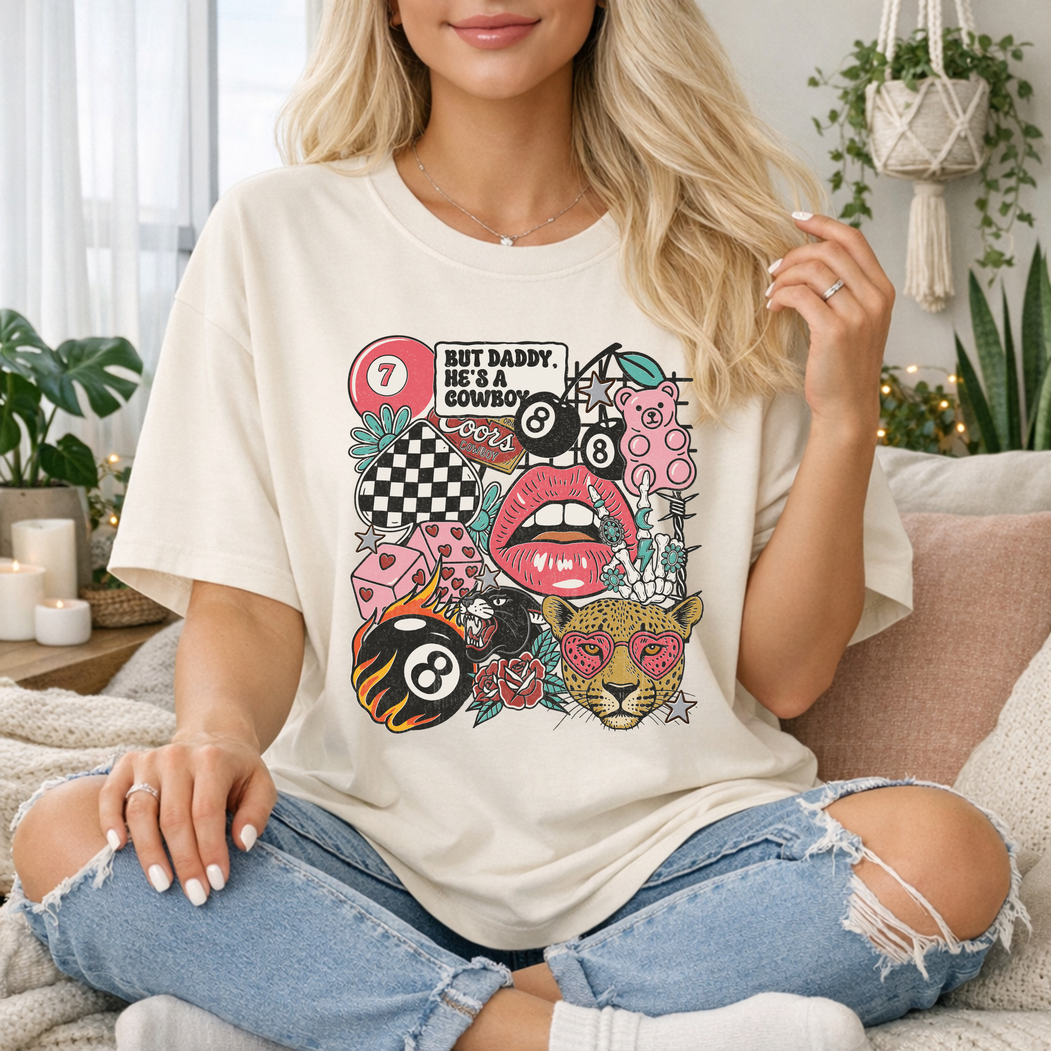 Person wearing a white t-shirt with colorful graphic design sitting on a couch.
